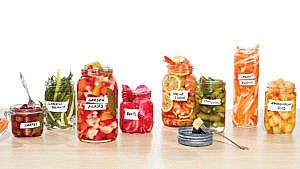 一张桌子上，八罐不同的泡菜食谱挨个放在一起。